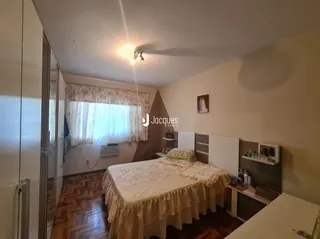 Quarto com cama e piso de madeira no interior da propriedade.