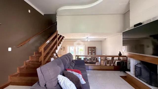 Sala de estar com sofá e escadaria em um imóvel no Brasil.