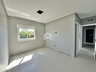 Vista interna de uma sala com piso claro e janela.
