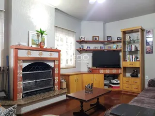 Sala de estar com lareira e estantes de madeira em um imóvel no Brasil.