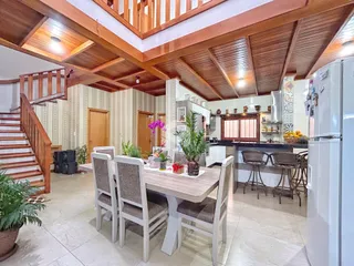 Foto de uma sala de jantar em um imóvel no Brasil com piso de cerâmica e detalhes em madeira.