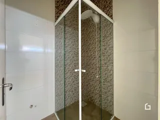 Foto de um banheiro com box de vidro e revestimento texturizado.