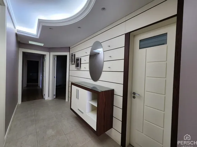 Hall de entrada com painel decorativo e espelho em um imóvel em Lajeado.