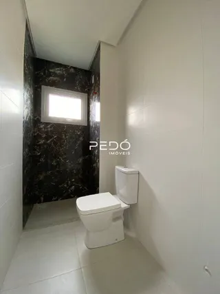 Interior de um banheiro com revestimento de parede escuro.