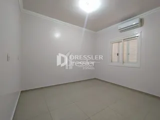 Ambiente interno de uma sala com paredes brancas e piso claro.