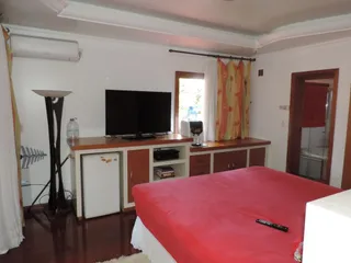 Quarto com cama e televisão em ambiente interno.