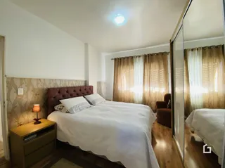 Quarto com cama e cortinas em madeira.