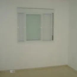 Parede branca com uma janela retangular em uma sala.