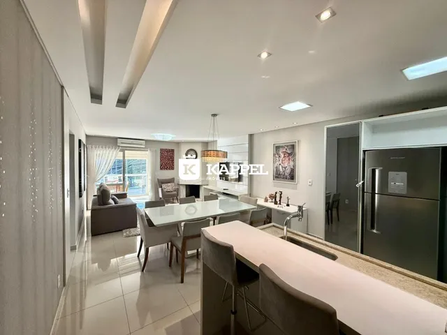 Sala de estar e jantar com cozinha aberta em um apartamento moderno.