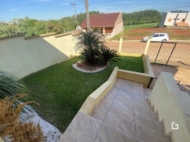 Vista do quintal de uma propriedade em Lajeado, Brasil, com gramado e muro.