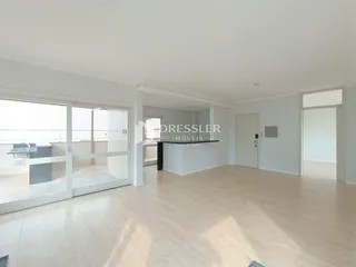 Sala de estar ampla com piso de madeira clara e portas de vidro que dão acesso ao exterior.