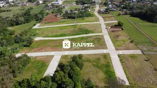 Vista aérea de um terreno aberto com campos gramados e estradas rurais.