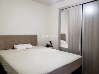 Quarto com cama e armário de casal em um imóvel.
