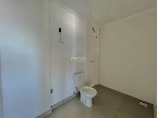 Foto de um corredor interno com um vaso sanitário branco.