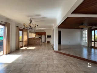Interior de uma sala de estar com piso de cerâmica e teto alto.
