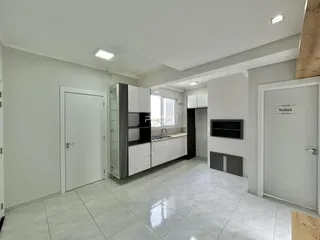 Foto de um corredor interno de uma residência com piso de cerâmica clara.