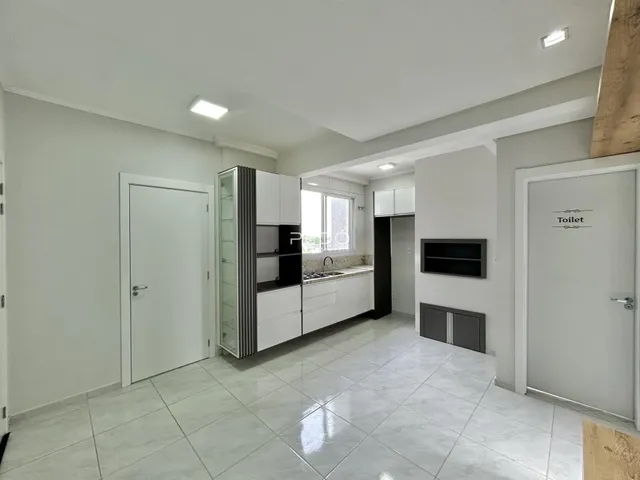 Foto de um corredor interno de uma residência com piso de cerâmica clara.