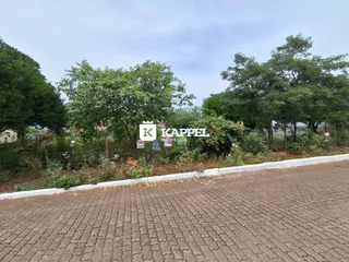 Vista externa de uma propriedade com vegetação densa ao fundo.
