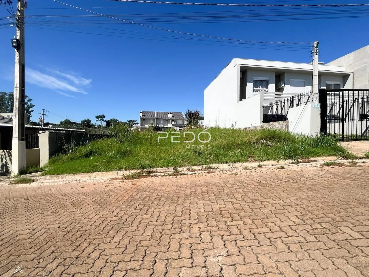 Vista externa de uma residência branca em Lajeado, Brasil, com cerca e jardim.
