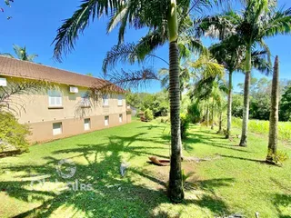 Vista externa de uma casa com jardim gramado e palmeiras em Lajeado, Brasil.