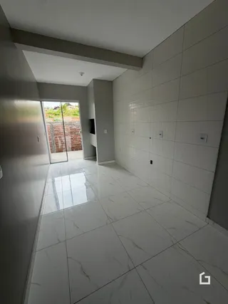 Hall de entrada com piso e paredes de cerâmica branca.
