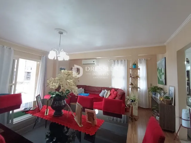 Sala de estar com decoração vermelha e vista para a janela.
