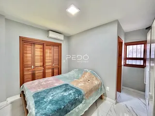 Quarto com armários de madeira e cama no interior de uma residência.