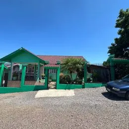 Vista externa de uma propriedade com cerca verde e vegetação em Lajeado, Brasil.
