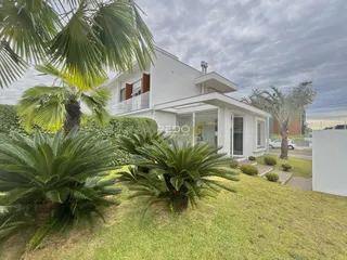 Fachada de uma casa branca com jardim verde em Lajeado, Brasil.