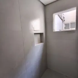 Parede interna branca com um nicho em uma residência.