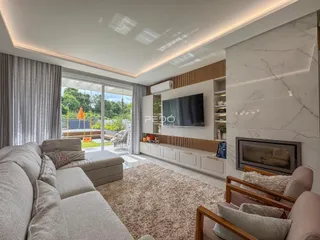 Sala de estar moderna com lareira e grandes janelas de vidro.