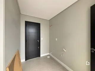 Hall de entrada com porta escura e piso claro em imóvel no Brasil.