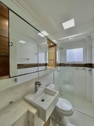 Banheiro moderno com revestimento de mármore e azulejos brancos.