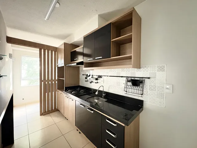 Foto da cozinha com armários de madeira e bancada escura.