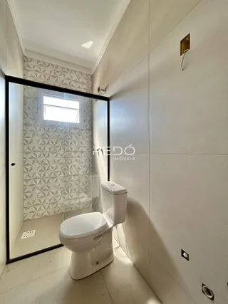 Foto de um banheiro com revestimento de azulejos brancos e cinzas.