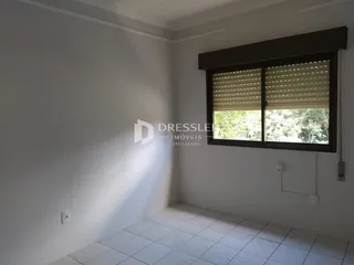 Interior de uma sala com paredes brancas e piso de cerâmica.
