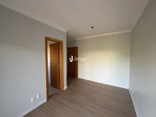 Hall de entrada com piso de madeira e porta de madeira.