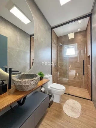 Foto de um banheiro moderno com box de vidro e revestimento de madeira.
