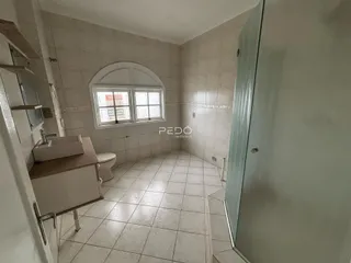 Foto de um banheiro com piso de cerâmica claro e janela arqueada.