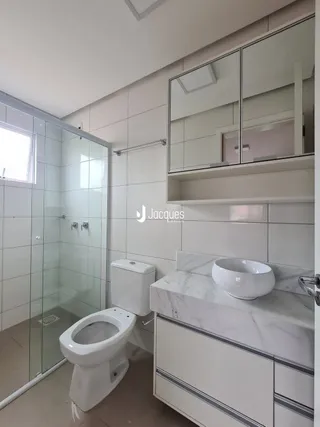 Foto de um banheiro com revestimento branco e vaso sanitário.