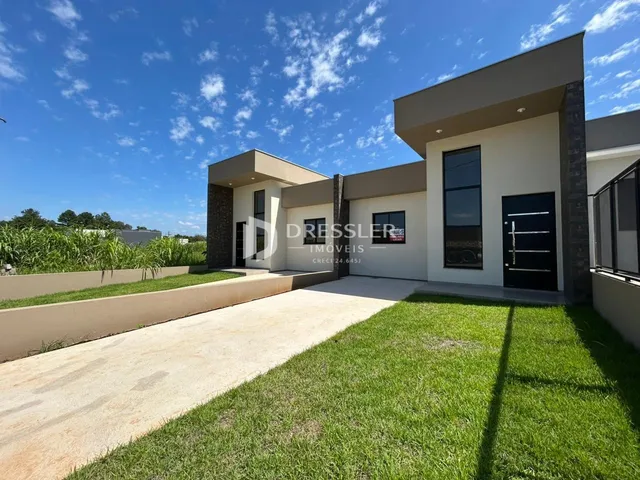 Fachada de uma residência em Lajeado, Brasil, com jardim e entrada de concreto.