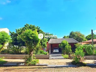 Fachada de uma residência em Lajeado, Brasil, com cerca e vegetação ao fundo.