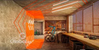 Ambiente interno de um espaço com paredes de concreto aparente e iluminação moderna.