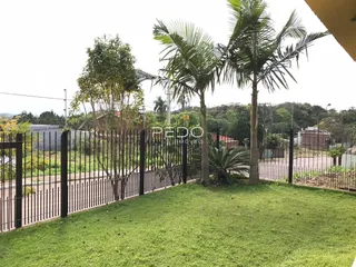 Vista do quintal de uma propriedade em Lajeado com cerca e vegetação.
