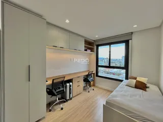Quarto com armários embutidos e vista da cidade.