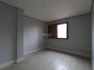 Interior de uma sala com paredes cinzas e piso claro.