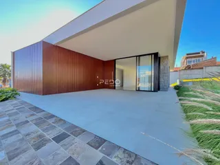 Fachada moderna de uma residência com revestimento de madeira e piso externo em Lajeado.