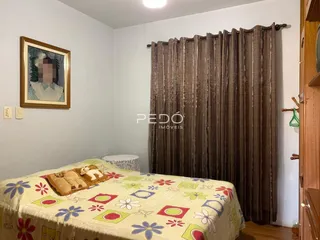 Quarto interno com cama e cortinas em uma sala.