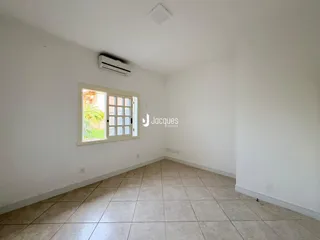 Interior de uma sala com piso de cerâmica e paredes brancas.