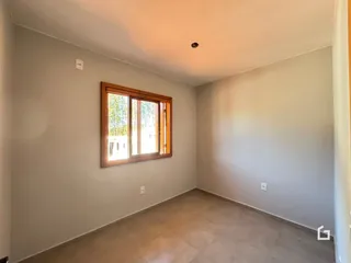 Ambiente interno com piso de cerâmica e janela de madeira.